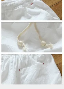 Detail view of white cotton linen shorts showing waistband drawstring and pocket texture