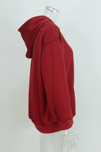 Side profile of red oversized hooded sweatshirt with pockets and ribbed cuffs.