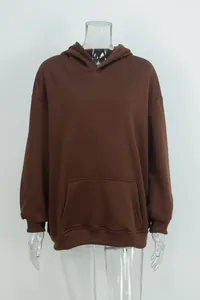 Close-up detail of a solid brown oversized hoodie with front pocket on transparent mannequin