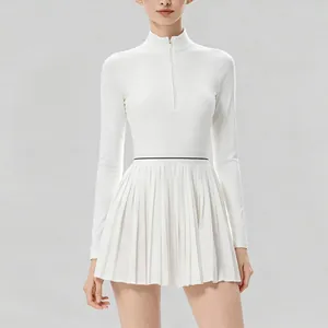 Vista detallada de un vestido de tenis blanco plisado con manga larga y media cremallera frontal