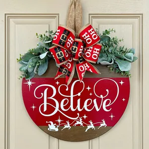 Rustic Christmas wooden Believe door hanger with greenery and a festive red bow