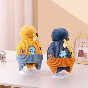 Detail view of colorful infant knit hats with ear flaps and cute animal patches.