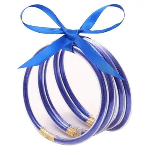 Set di 5 braccialetti in silicone blu glitterato con fiocco decorativo in nastro di raso blu.