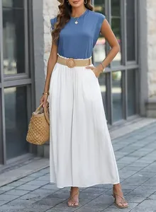 Model wearing a blue sleeveless cap sleeve T-shirt paired with white wide-leg pleated pants.