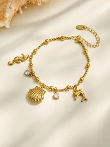 Gros plan du bracelet plaqué or 18 carats avec breloques coquillage, dauphin et hippocampe