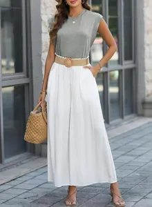 Detail view of woman in grey cap-sleeve top and white wide-leg trousers with belt