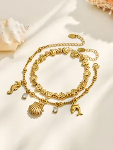 Détail de bracelets plaqués or 18k avec perles en cœur et breloques marines