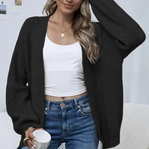Oversized black chunky knit cardigan with lantern sleeves worn by a model over jeans