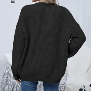 Back view of a women's oversized black chunky knit cardigan featuring cozy lantern sleeves