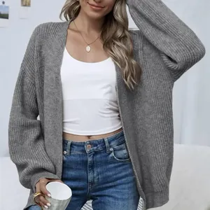 Detail of a grey chunky knit cardigan with relaxed lantern sleeves and a cozy texture.