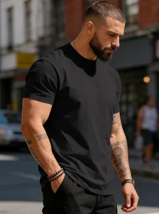 Detailed view of plain black cotton crew neck t-shirt on male model in street setting