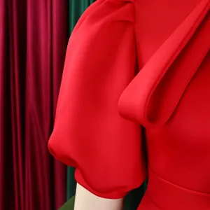Gros plan d'une robe rouge avec manches bouffantes et détail chic de nœud d'épaule