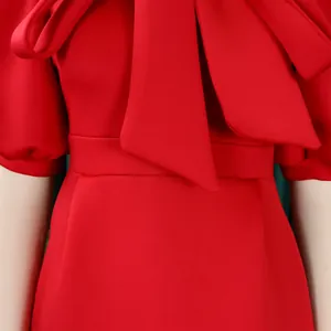 Gros plan détaillé d'une robe de soirée rouge avec un grand nœud et des détails à la taille