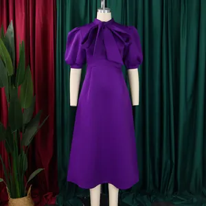 Vue détaillée d'une robe violette à manches bouffantes avec un grand nœud au col