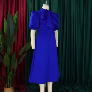 Élégante robe de cocktail bleu royal avec manches bouffantes et un grand nœud papillon.