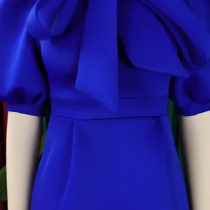 Détail d'une robe de soirée bleu roi avec un grand nœud et des manches bouffantes.