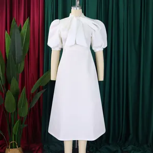 Robe midi blanche élégante avec col à nœud et manches bouffantes pour une soirée.