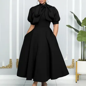Robe mi-longue noire élégante avec grand nœud papillon et manches bouffantes pour soirées.