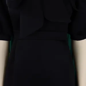 Détail d'une robe de cocktail noire avec un élégant nœud papillon à la poitrine