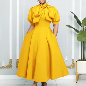 Vue détaillée de la robe de soirée jaune à manches courtes avec nœud papillon et jupe évasée
