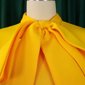 Gros plan sur l'élégant décolleté à nœud d'une robe de soirée d'été d'un jaune éclatant