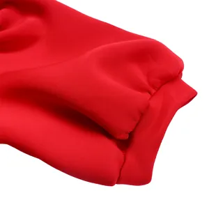 Vue détaillée du poignet élastiqué d'une robe de soirée rouge vif et élégante.
