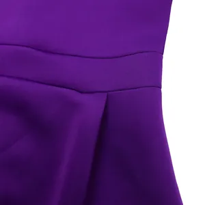 Détail d'une robe de soirée violette montrant la couture de taille et le tissu plissé