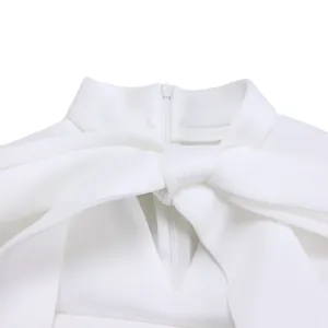 Gros plan détaillé de l'encolure d'une robe blanche avec un nœud et une fermeture