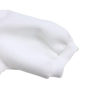Détail du revers de la manche bouffante blanche montrant la texture du tissu et les coutures.