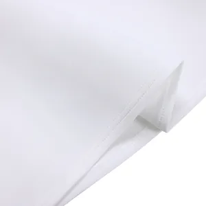 Détail macro du tissu d'une robe blanche montrant des coutures de haute qualité.