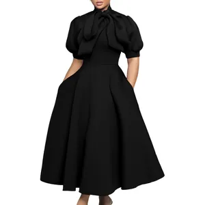 Vue de face d'une élégante robe de soirée noire avec un grand nœud et des manches bouffantes