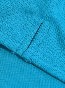 Macro detail van ademende mesh stof en versterkte zijsplitstiksels op een blauw poloshirt