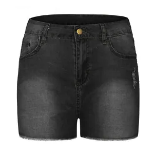 Detailed view of high waist black denim shorts with ripped accents and frayed hem