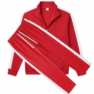 Detail view of men's red two-piece tracksuit with white side stripes and stand collar.