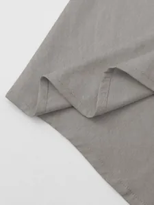 Detail shot of grey cotton-linen fabric texture and stitching for a men's hooded shirt.