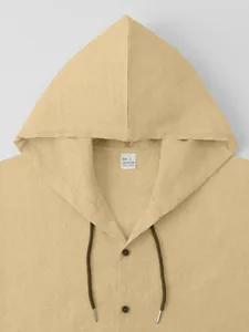 Detailed view of beige cotton linen men's hooded shirt showing neckline label and texture