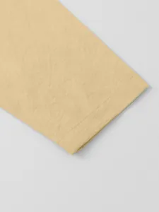 Macro detail of cotton linen shirt cuff showing precise stitching and natural fabric texture