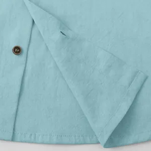 Close-up of light blue cotton linen men's shirt showing fabric texture and button