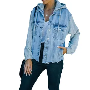 Women's oversized spliced denim jacket with grey hoodie and long sweatshirt sleeves.