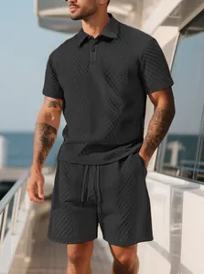 Vue détaillée d'un ensemble polo et short noir texturé pour homme sur un pont de yacht