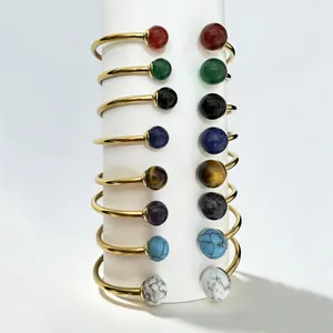 18K gold-plated stainless steel bangles with colorful gemstones on a white stand