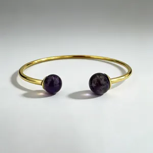 Detailed close-up of a 18K gold stainless steel cuff bracelet with purple gemstones