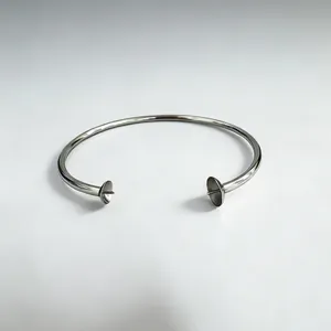 Macro detail of stainless steel open bangle setting for pearl and gemstone mounting