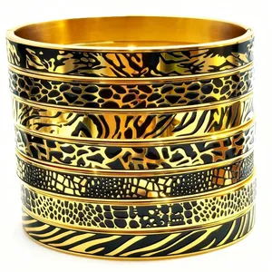 Detail shot of stackable 18K gold plated stainless steel bangles with black animal prints.