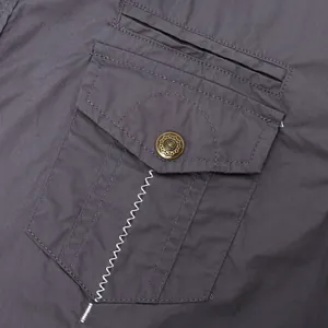 Primo piano di una tasca cargo su una camicia di cotone grigio scuro con cuciture bianche