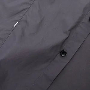 Dettaglio di una camicia da lavoro in cotone grigio antracite con bottoni e cuciture nere