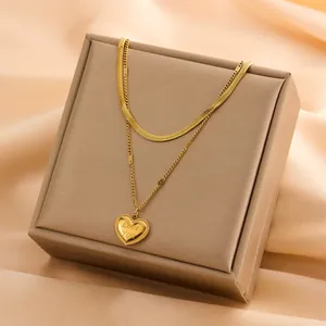 Detail view of a double-layered gold-plated necklace with engraved Love You heart pendant.