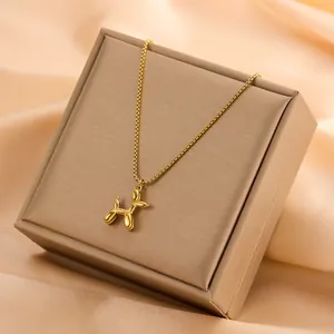 Close-up detail of a minimalist 18k gold plated balloon dog pendant on a premium necklace