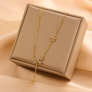 Close-up of elegant 18K gold plated titanium steel necklace with crystal bow knots