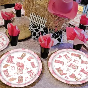 Detail view of pink cowboy theme party tableware with stylish boots and hat patterns